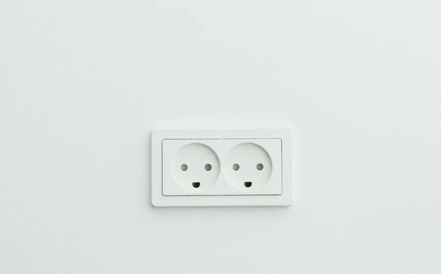 Enchufe doble blanco instalado en un muro claro